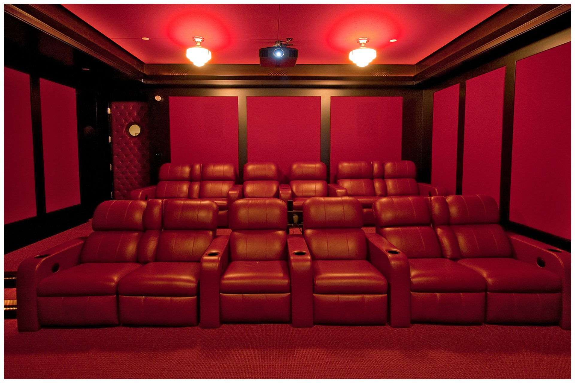 DEDICATED BASEMENT THEATER 12 seat dedicated basement theater with Acoustic paneling to limit sound intrusion outside the room. Front Speaker elements are enclosed into cabinetry and all other  speakers are placed under acoustical panels.Screen and seating are placed on the right side of the room to allow a wide isle leading to exit door in so doing, seats in the center are centered on the screen and front speakers.System is enclosed in an adjacent closet. JBL Synthesis speakers elements are hidden behind fabric in custom wall panelings.